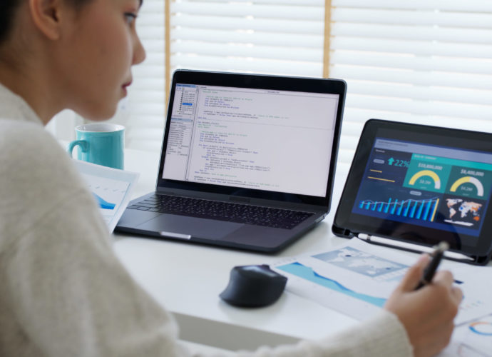 Back rear view of young asian woman, freelance data scientist work remotely at home