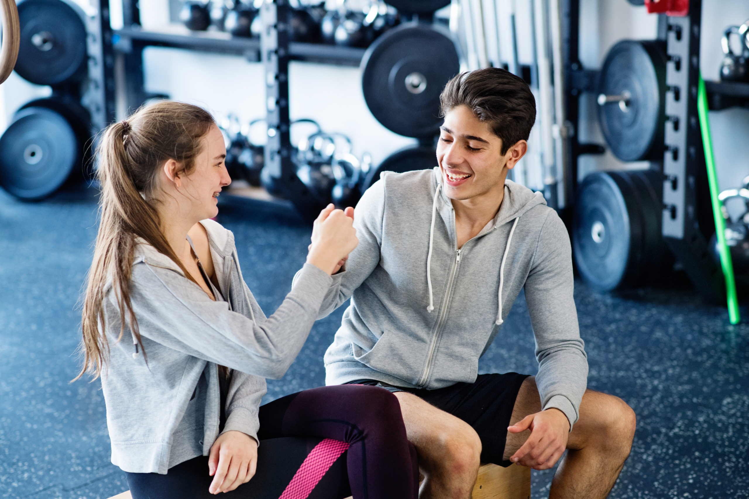 Young fit couple in crossfit gym doing fist pump.